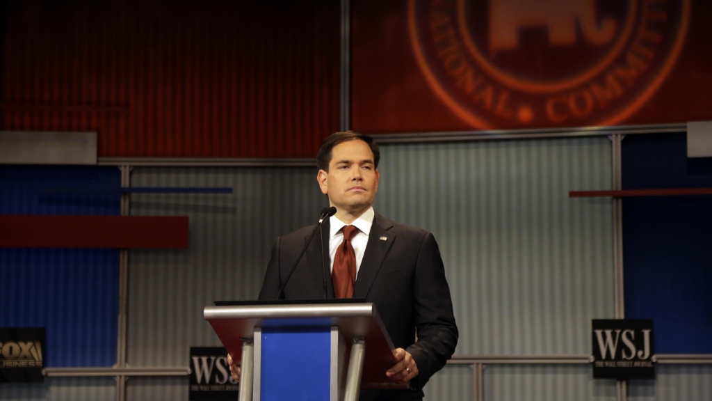 Marco Rubio stands alone during a Republican presidential debate in Milwaukee Tuesday. He spoke to NPR about a hot-button issue in that debate — immigration