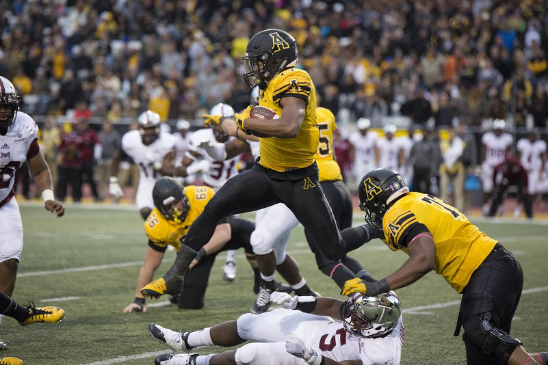 Running back Marcus Cox hurdles a defender during Saturday's triple overtime victory against Troy. Chris Deverell | The Appalachian