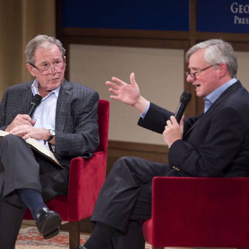 George W. Bush left listens to Pulitzer Prize winning author Jon Meacham right talk about his biography of Bush's father former President George H. W. Bush Sunday Nov. 8 2015 at the George W. Bush Presidential Center