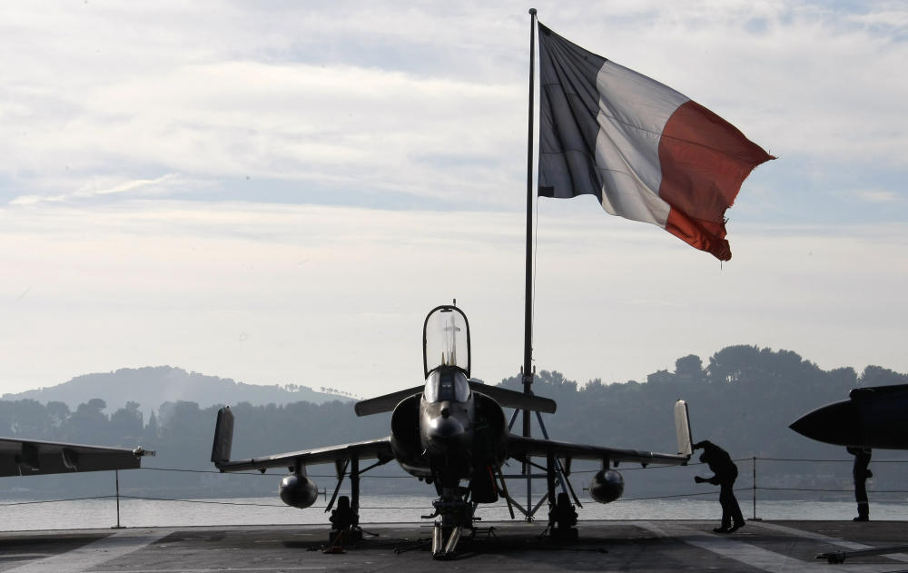 A French sailor checks a Super Etendard fighter jet on the deck of France's nuclear-powered aircraft carrier Charles de Gaulle before it leaves its home port of Toulon on Wednesday. France has deployed its aircraft carrier in the eastern Mediterranea