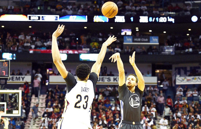 Stephen Curry of the Golden State Warriors takes a three-point shot over Anthony Davis of the New Orleans Pelicans during their game at the Smoothie King Center in New Orleans Louisiana Saturday. — AFP