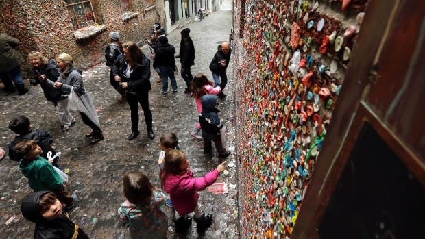 Visitors check out Seattle's'gum wall at Pike Place Market Monday Nov. 9 2015. Known as the'gum wall' the sticky landmark has become a popular attraction to visitors and locals