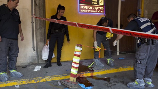 Israeli police investigates the scene of an stabbing attack in Tel Aviv on Thursday. A Palestinian man fatally stabbed two Israeli men in a Tel Aviv office building before being apprehended police said