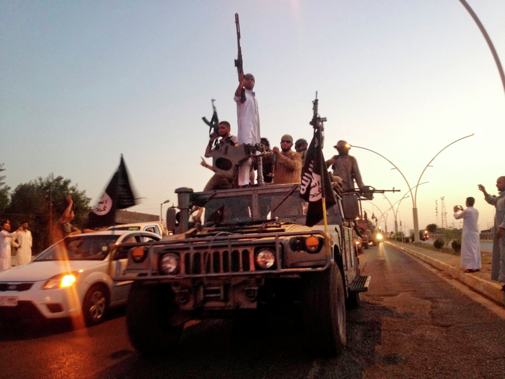 23 2014 fighters from the Islamic State group parade in a commandeered Iraqi security forces armored vehicle down a main road at the northern city of Mosul Iraq