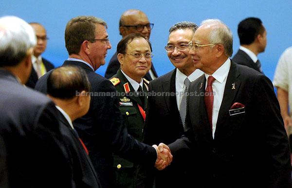 Prime Minister Datuk Seri Najib Tun Razak greets Carter upon his arrival during the meeting while Hishammuddin looks on. — Bernama