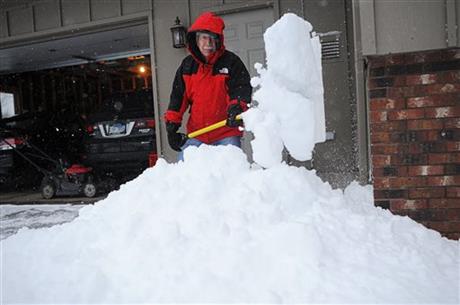 Jim Paulson of Sioux Falls shovels part of his driveway before using the snow blower to clear the rest during the first snow of the season Friday Nov. 20 2015 in Sioux Falls