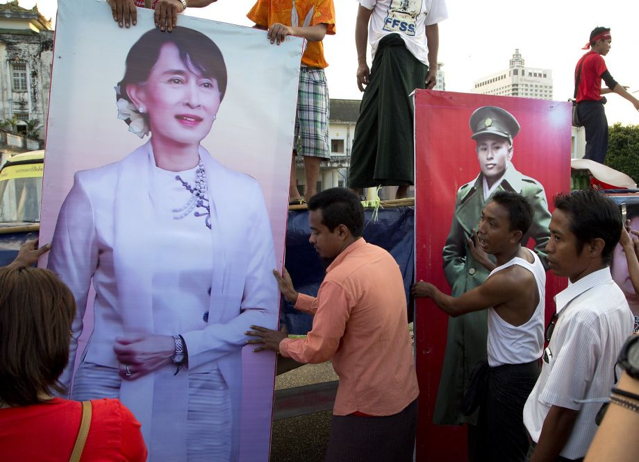 Supporters of Aung San Suu Kyi place posters of her and her late father Aung San on the final day of campaigning in Rangoon