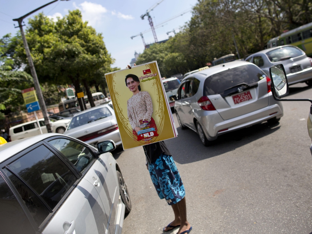 A vendor holds a calendar featuring Myanmar's opposition leader Aung San Suu Kyi in Myanmar. Myanmar's current president has promised a peaceful transfer of power