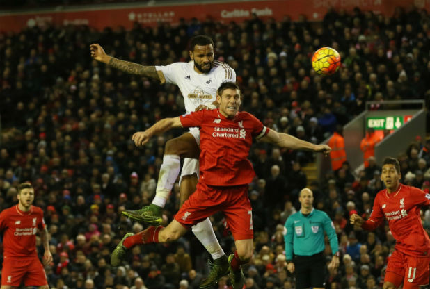 Swansea City's Kyle Bartley towers above Liverpool skipper James Milner at Anfield