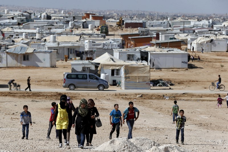 Syrian refugees walk at Al Zaatari refugee camp in the Jordanian city of Mafraq near the border with Syria