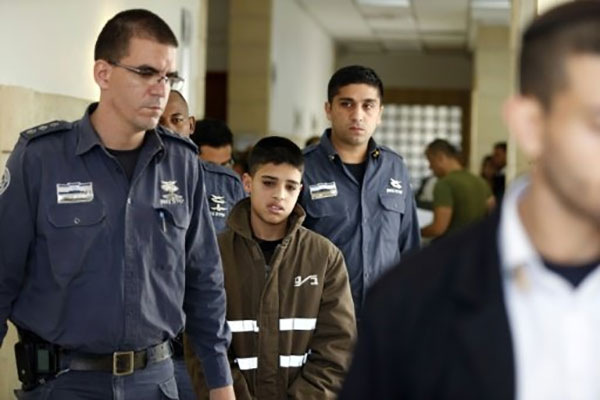 Ahmed Manasra, a 13-year old Palestinian accused of taking part in the stabbing of two Israelis earlier this month is escorted by Israeli security during a hearing at a Jerusalem court