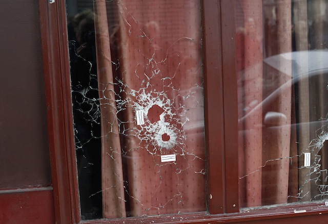 Bullet holes mark the front window of the Carillon cafe in Paris Saturday Nov.14 2015. French President Francois Hollande vowed to attack Islamic State without mercy as the jihadist group admitted responsibility Saturday for orchestrating the deadlies