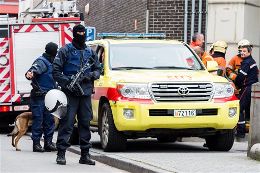 Armed police guard a street in Brussels on Monday Nov. 16 2015. A major action with heavily armed police is underway in the Brussels neighborhood of Molenbeek amid a manhunt for a suspect of the Paris attacks