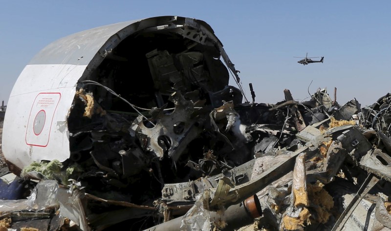 An Egyptian military helicopter flies over debris from a Russian airliner which crashed at the Hassana area in Arish city north Egypt in this file