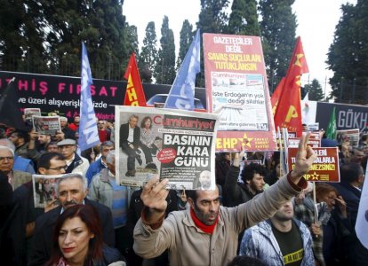 A demonstrator holds newspaper read