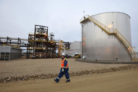 An oilfield worker walks past the Statoil oil sands facility near Conklin Alberta in this