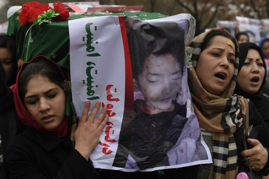 Afghan protesters carry a coffin containing a decapitated body of one of seven Shiite Muslim Hazaras including four men two women and one child during a demonstration in Kabul