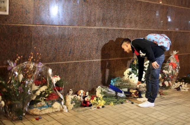 A Russian young man lays flowers in front of the Russian embassy in Cairo to commemorate victims of the Russian airplane crash at the Sinai Egypt