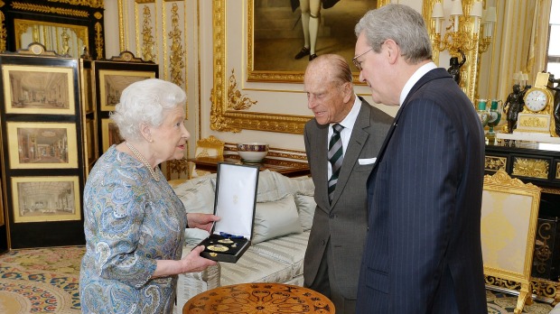 The Queen gives the Duke of Edinburgh the Insignia of a Knight of the Order of Australia in the presence of Alexander Downer in April