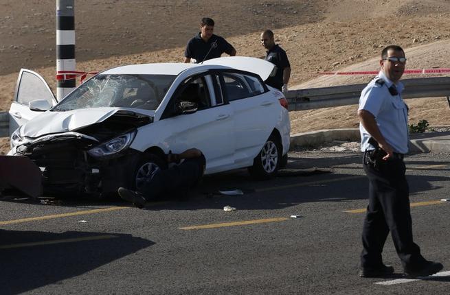 Israeli security forces stand at the site where a Palestinian man allegedly rammed his car into Israelis soldiers standing by a bus station on a highway next the Jewish settlement of Kfar Adumim