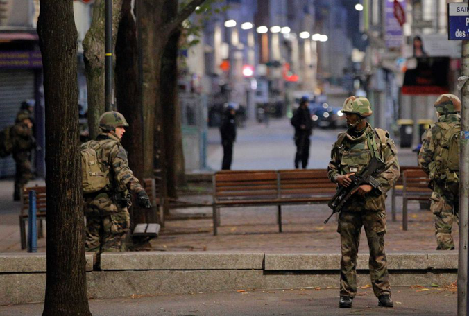 Soldiers patrol in St. Denis a northern suburb of Paris Wednesday Nov. 18 2015. Authorities in the Paris suburb of St. Denis are telling residents to stay inside during a large police operation near France's national stadium that two officials say