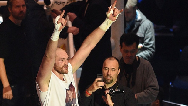 Britain's Tyson Fury left celebrates after winning a world heavyweight title fight for Ukraine's Wladimir Klitschko's WBA IBF WBO and IBO belts in the Esprit Arena in Duesseldorf Germany on Saturday