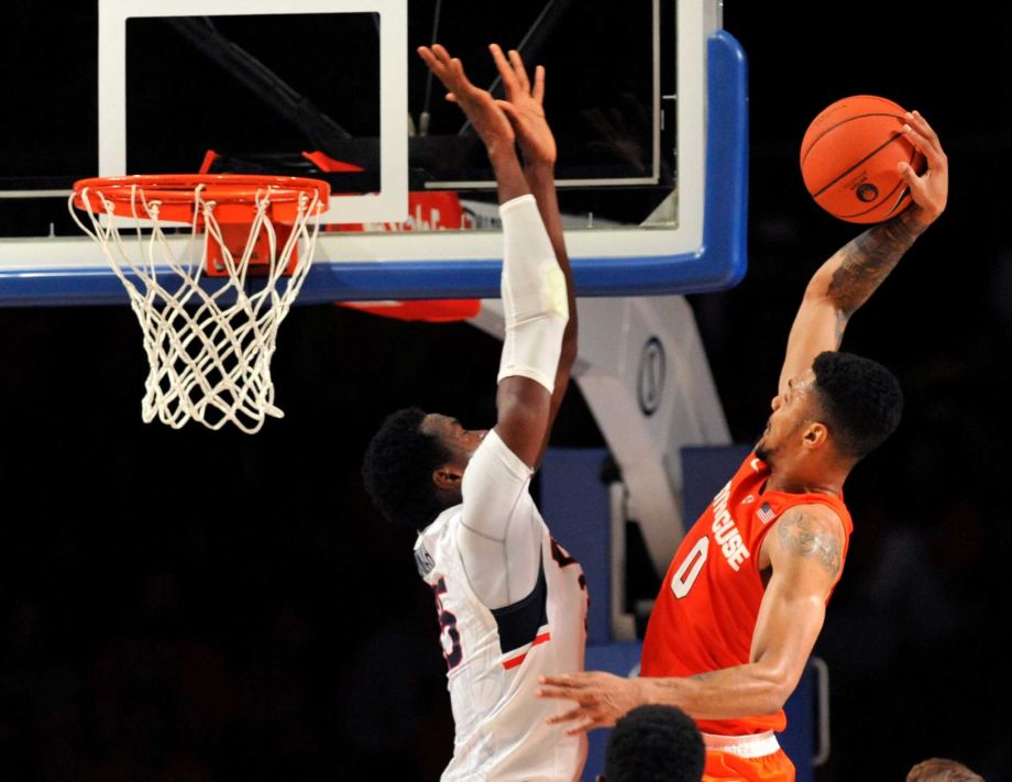 Syracuse forward Michael Gbinije takes the ball to the basket as Connecticut center Amida Brimah defends during an NCAA college basketball game in the semifinals of the Battle 4 Atlantis Thursday Nov. 26 2015. Syracuse defeated Connecticut 79