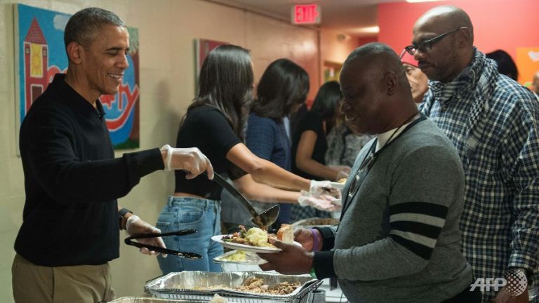 US President Barack Obama serves Thanksgiving dinner to homeless military veterans at Friendship Place in Washington DC