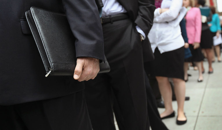 People stand in a line that stretched around the block to enter a job fair