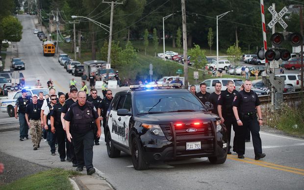 US officers escort the family of police officer Lt. Joe Gliniewicz from a vigil held in his honor in Fox Lake Illinois