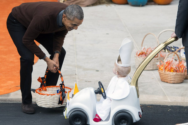 President Obama greets a young child dressed as the pope as he hands out treats to children trick-or-treating for Halloween on the South Lawn of the White House in Washington on Oct. 30 2015