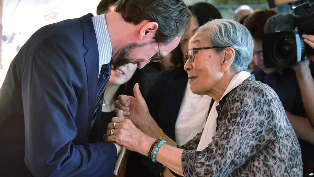 U.N. High Commissioner for Human Rights Zeid Ra'ad Al Hussein left is greeted by former South Korean comfort woman Kim Bock-dong who was forced to serve for the Japanese troops as a sexual slave during World War II as he visits the War and Women