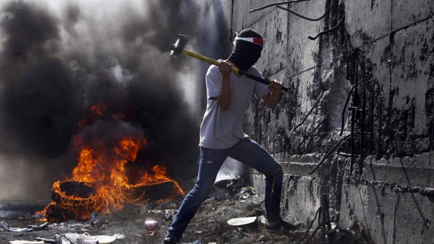 Unrest A Palestinian student tries to break the separation barrier between the West Bank and Israel