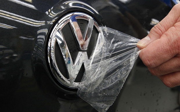 A protective cover is removed from a Volkswagen AG logo at the company's factory in Wolsburg Germany on Friday Feb. 25 2011