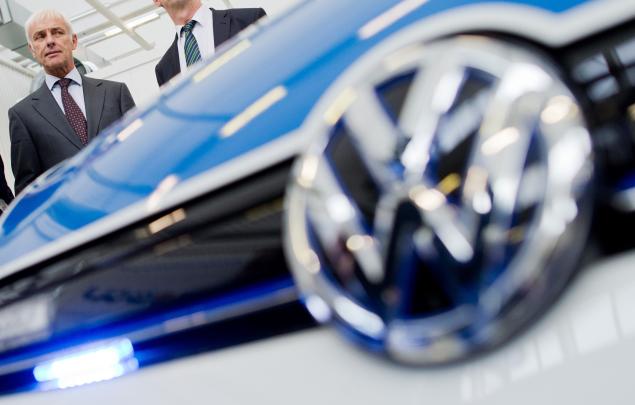 Matthias Mueller CEO of German car maker Volkswagen and Lower Saxony State Premier and Volkswagen's Supervisory board member Stephan Weil pose next to VW electric Golf Police car during a visit to the VW plant in Wolfsburg central Germany on Octobe