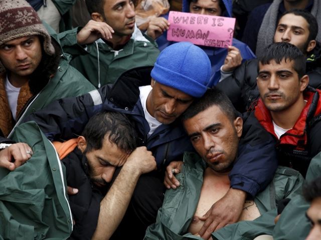 Stranded Iranian migrants on hunger strike some with their lips sewn together sit on rail tracks at the borderline between Greece and Macedonia near the Greek village of Idomeni