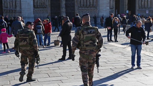 French soldiers patrol outside Notre Dame Cathedral in Paris on Sunday as police in France and Belgium continued to hunt down perpetrators of the Nov. 13 massacre