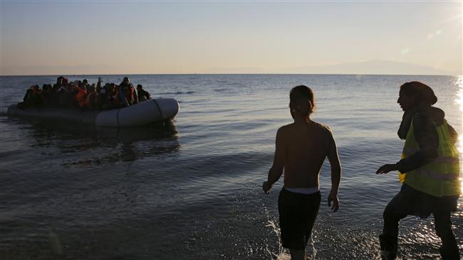 Volunteers approach a raft overcrowded with refugees at dawn on the Greek island of Lesbos