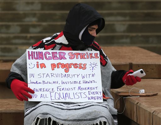 Hunger striker John Cowan a a 2014 University of Kansas graduate checks his phone while protesting on the University of Kansas campus on Monday Nov. 16 2015 in Lawrence Kan. Protest leaders at the University of Kansas said Monday that theyre push