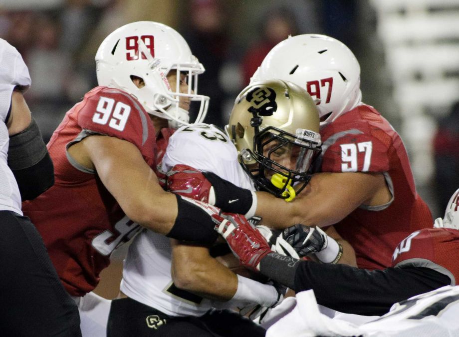 Washington State defensive linemen Darryl Paulo and Destiny Vaeao take down Colorado running back Phillip Lindsay during the first half of an NCAA college football game Saturday Nov. 21 2015 in Pullman Wash