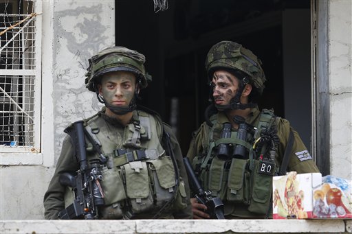 Israeli soldiers stand outside a Palestinian house during a search near the Tel Rumeida settlement in the West Bank city of Hebron Saturday Nov. 7 2015. Three assaults took place Friday in Hebron the West Bank's largest city which has been the