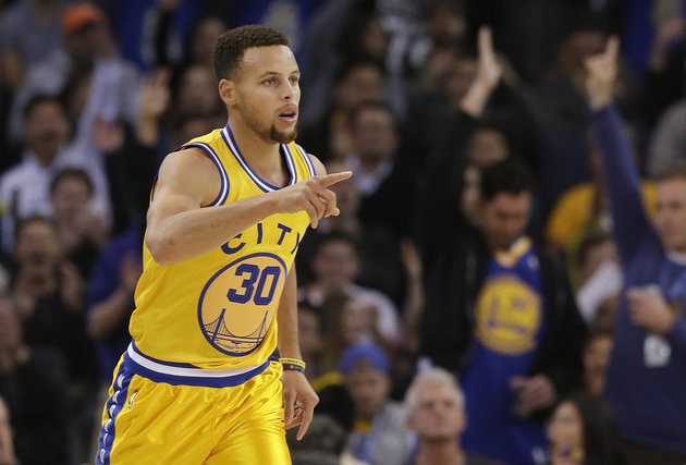 Golden State Warriors guard Stephen Curry reacts after making a 3-point basket during the first half of an NBA basketball game against the Los Angeles Lakers in Oakland on Tuesday