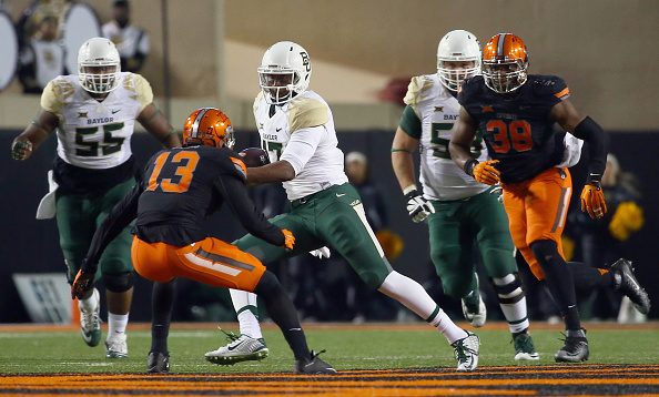 STILLWATER OK- NOVEMBER 21 Chris Johnson #13 of the Baylor Bears carries the ball against Trace Clark #90 of the Oklahoma State Cowboys and Jordan Sterns #13 of the Oklahoma State Cowboys in the fourth quarter at Boone Pickens Stadium