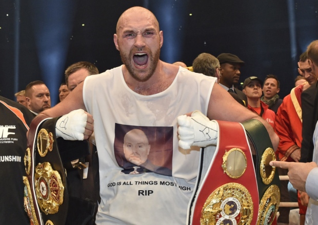 Britain's new world champion Tyson Fury celebrates with the WBA IBF WBO and IBO belts after winning the world heavyweight title fight against Ukraine's Wladimir Klitschko. AP