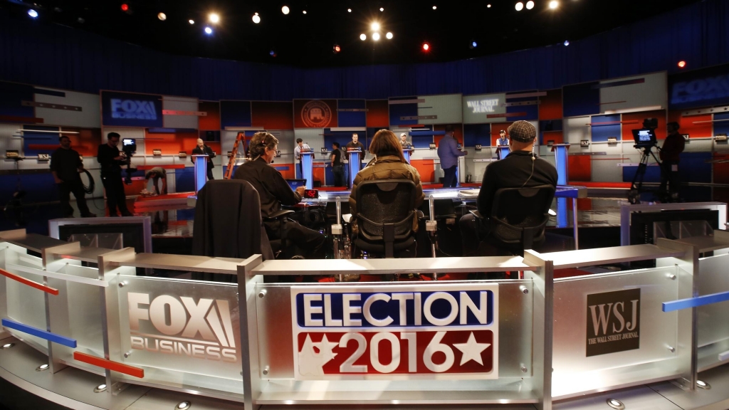 Workers stand in at the candidate's podiums Monday Nov. 9 2015 in preparation of for Tuesday's Republican debate in Milwaukee