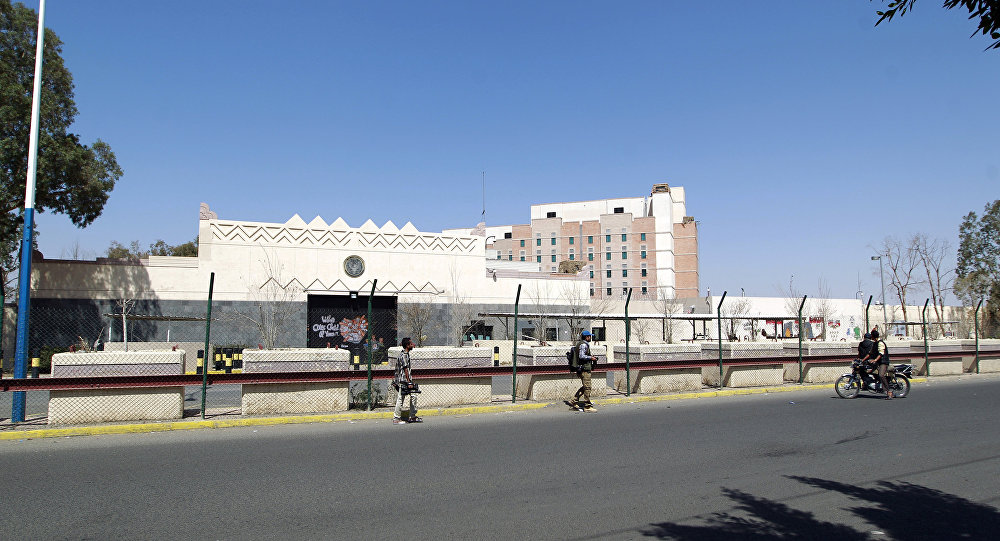 Yemenis walk past the compound of the US embassy in the Yemeni capital Sanaa