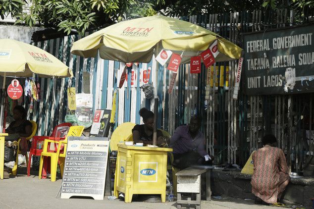 People sell MTN phone cards on a street in Lagos Nigeria Thursday Nov. 5 2015. Africa's biggest telecommunications company is locked in a nasty battle with one of the most powerful governments on the continent with billions of dollars at stake. M