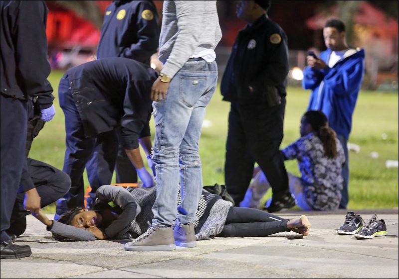 People await transport to a hospital after a shooting in New Orleans on Sunday