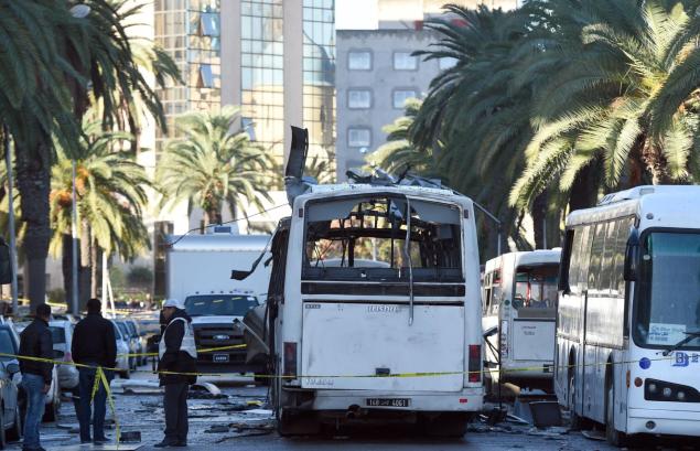 Tunisian authorities inspect the wreckage of an attack on a bus transporting Tunisia's presidential guard in central Tunis Nov. 25 2015