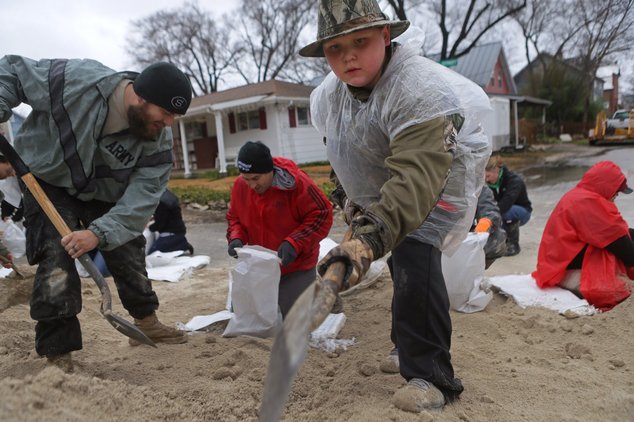 Jayden Covert 10 of Kimmswick Mo. joins other volunteers in sandbagging efforts as the Mississippi River rises after several days of rain in Kimmswick